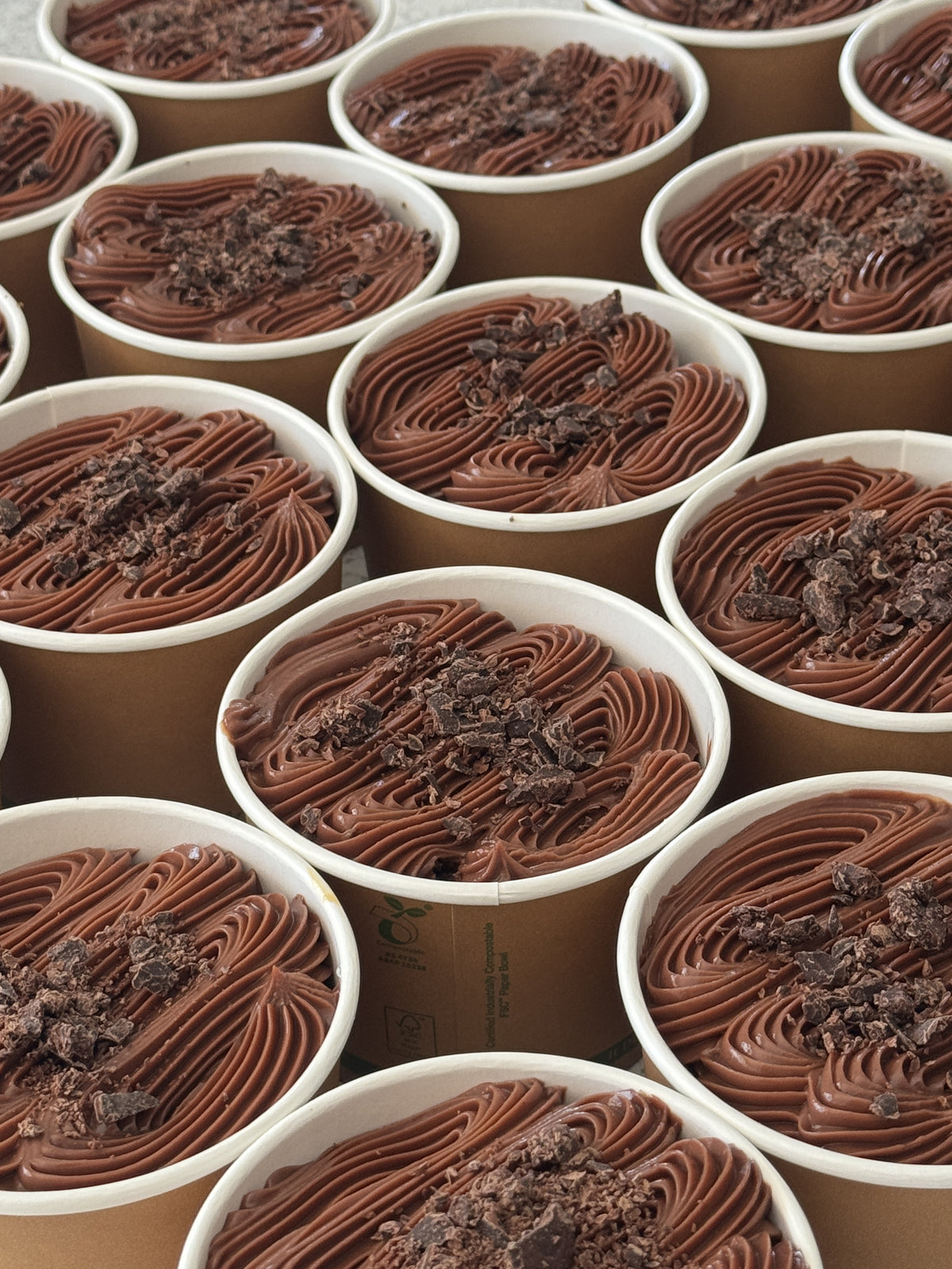 Chocolúcuma dessert cups with chocolate fudge and chocolate shavings, made with chocolate cake and homemade lúcuma dulce de leche.