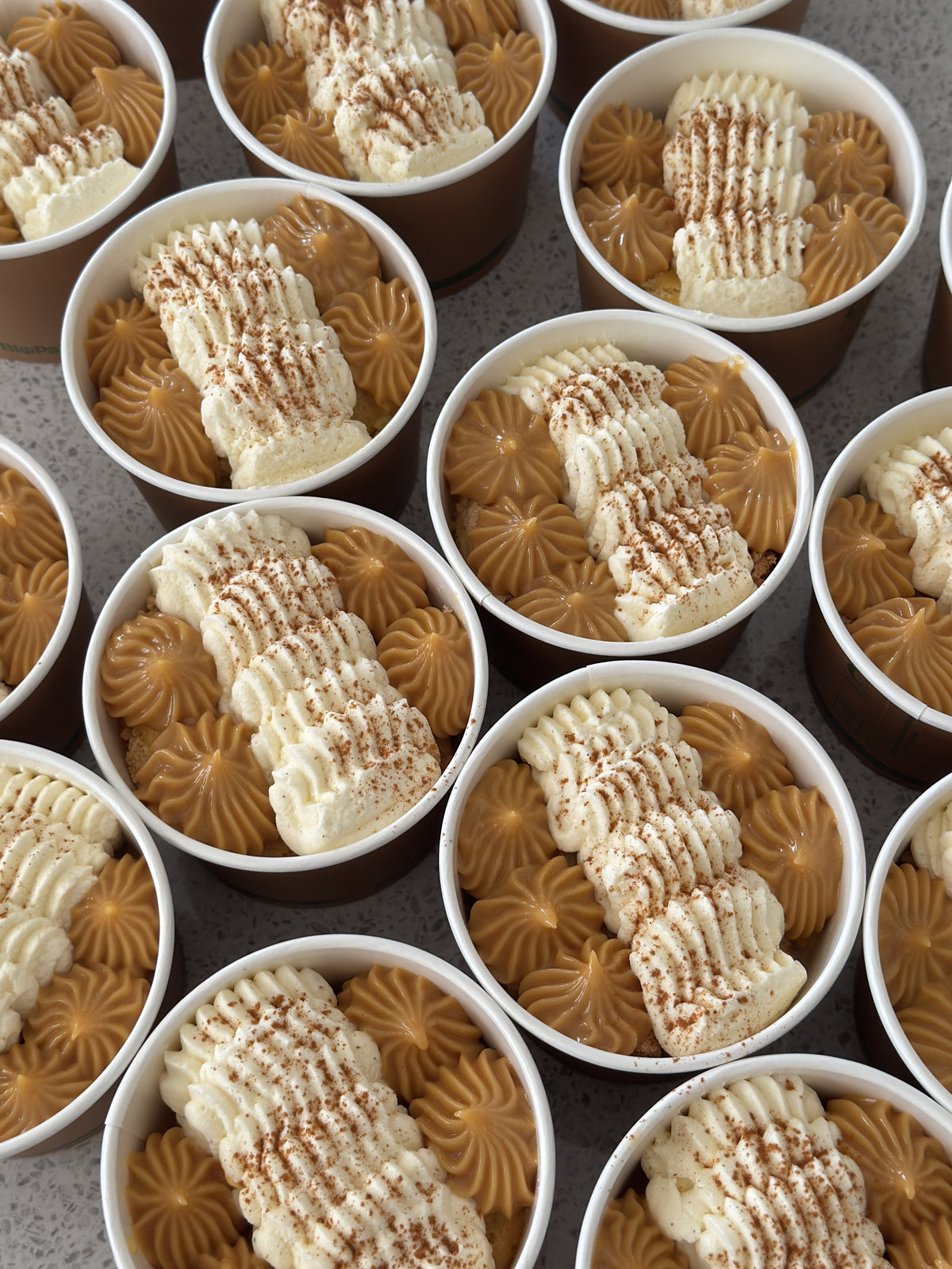 Lúcuma tres leches dessert cups topped with whipped cream and homemade lúcuma dulce de leche.